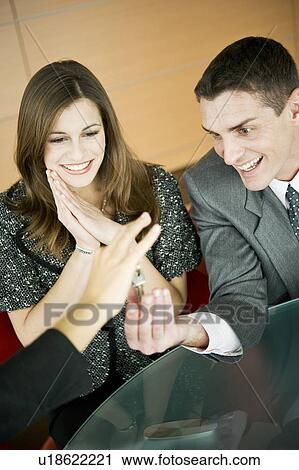 Couple receiving keys from female hand View Large Photo Image Stock Image - Couple receiving keys from female hand. Fotosearch