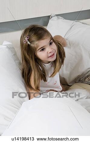 Girl sitting on bed View Large Photo Image Stock Image - Girl sitting on bed. Fotosearch