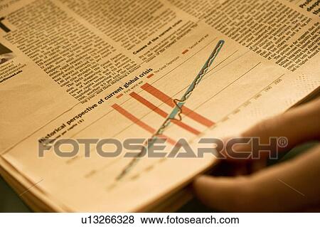 Hand holding newspaper with chart analyzing financial crisis View Large Photo Image Stock Photo - Hand holding newspaper with chart analyzing financial crisis. Fotosearch