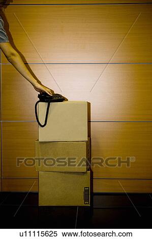 Hand on telephone on cardboard boxes in office View Large Photo Image Stock Photography - Hand on telephone on cardboard boxes in office. Fotosearch