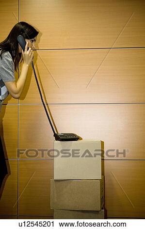 Office worker on telephone on cardboard boxes in office View Large Photo Image Stock Image - Office worker on telephone on cardboard boxes in office. Fotosearch