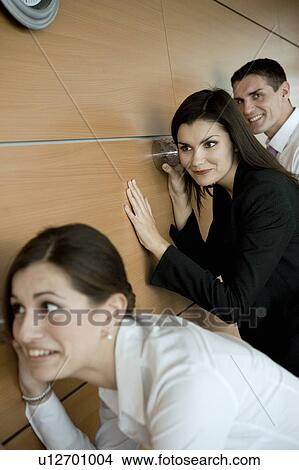 Office workers eavesdropping against wall View Large Photo Image Picture - Office workers eavesdropping against wall. Fotosearch