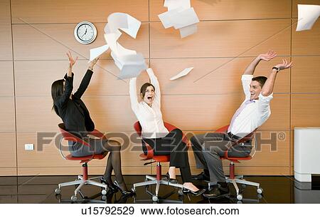 Stock Photo - Office workers throwing documents up in the air. Fotosearch