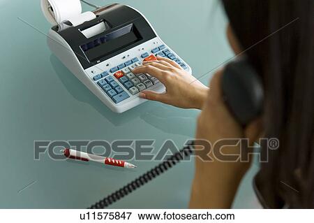 Professional woman on telephone using calculator View Large Photo Image Stock Photo - Professional woman on telephone using calculator. Fotosearch