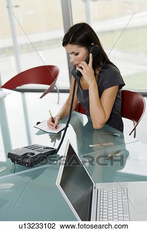 Professional woman on telephone writing in agenda View Large Photo Image Stock Image - Professional woman on telephone writing in agenda. Fotosearch