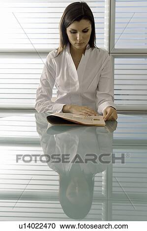 Professional woman reading newspaper at desk View Large Photo Image Stock Image - Professional woman reading newspaper at desk. Fotosearch