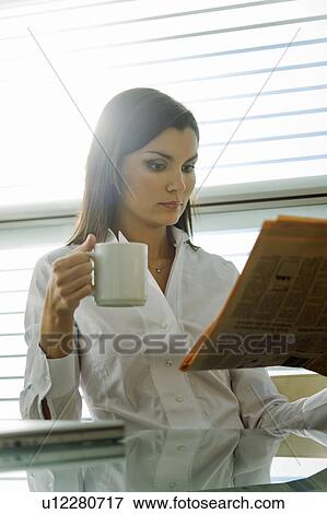 Professional woman reading newspaper and drinking coffee View Large Photo Image Stock Photo - Professional woman reading newspaper and drinking coffee. Fotosearch