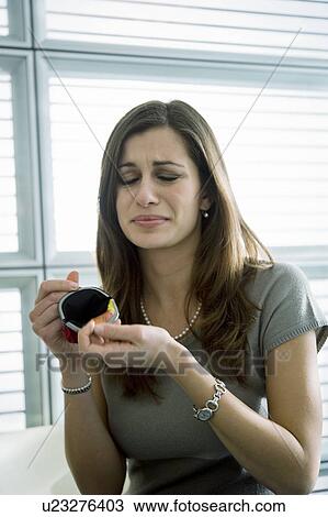 Stock Image - Professional woman showing empty purse. Fotosearch