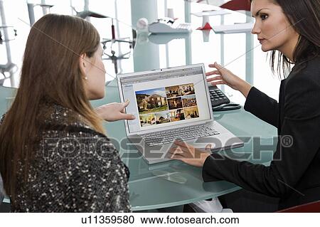 Stock Image - Two women at laptop computer. Fotosearch