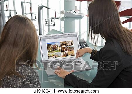 Stock Image - Two women at laptop computer. Fotosearch