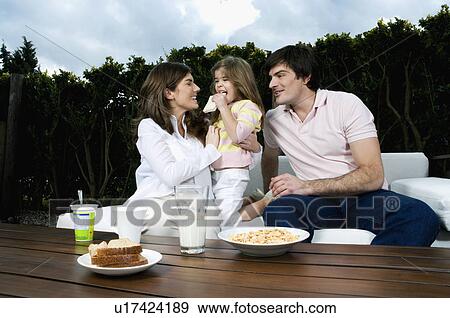 Young couple and girl having breakfast outdoors View Large Photo Image Stock Photo - Young couple and girl having breakfast outdoors. Fotosearch