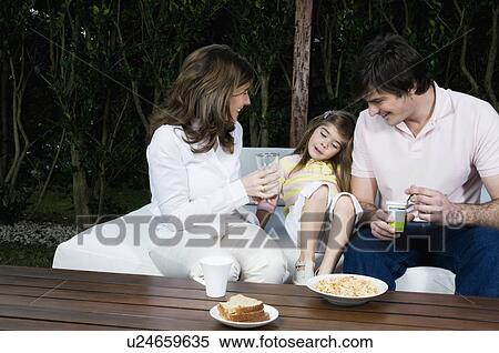 Young couple and girl having breakfast outdoors View Large Photo Image Stock Photography - Young couple and girl having breakfast outdoors. Fotosearch