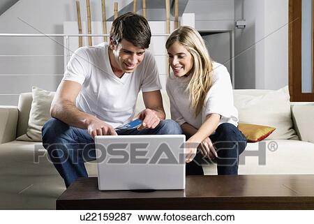 Young couple at laptop computer with credit card View Large Photo Image Stock Photo - Young couple at laptop computer with credit card. Fotosearch