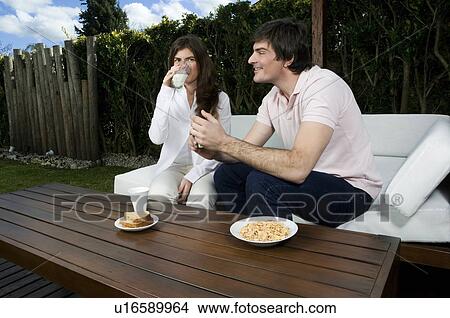 Young couple having breakfast outdoors View Large Photo Image Picture - Young couple having breakfast outdoors. Fotosearch