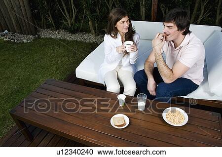 Young couple having breakfast outdoors View Large Photo Image Stock Image - Young couple having breakfast outdoors. Fotosearch