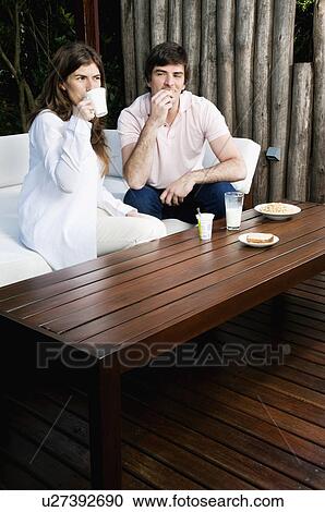 Stock Image - Young couple having breakfast outdoors. Fotosearch