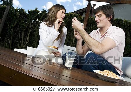 Stock Photo - Young couple having breakfast outdoors. Fotosearch
