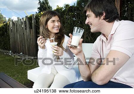 Stock Photo - Young couple having breakfast outdoors. Fotosearch