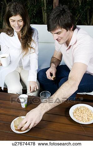 Young couple having breakfast outdoors View Large Photo Image Stock Photo - Young couple having breakfast outdoors. Fotosearch