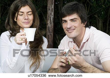 Stock Photograph - Young couple having breakfast outdoors. Fotosearch