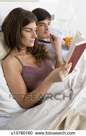 Young couple in bed relaxing View Large Photo Image Stock Image - Young couple in bed relaxing. Fotosearch