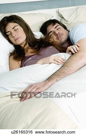 Young couple in bed sleeping View Large Photo Image Stock Photograph - Young couple in bed sleeping. Fotosearch