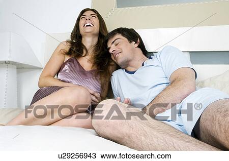 Young couple lying in bed View Large Photo Image Stock Image - Young couple lying in bed. Fotosearch