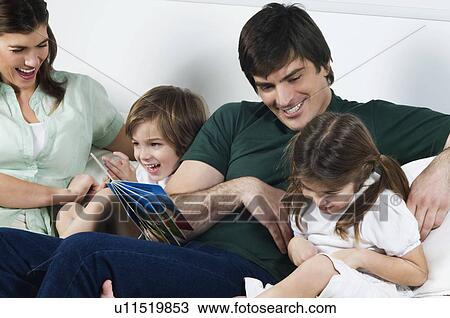 Young couple on couch with children reading View Large Photo Image Stock Image - Young couple on couch with children reading. Fotosearch