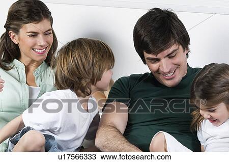 Young couple on couch with children View Large Photo Image Stock Image - Young couple on couch with children. Fotosearch