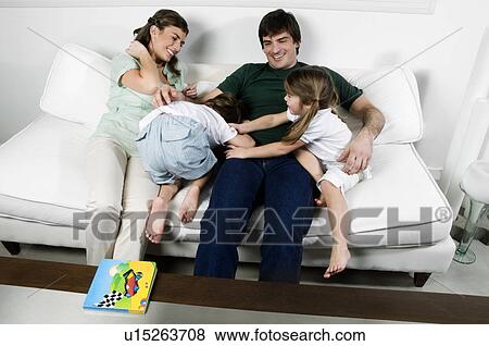 Young couple on couch with children playing View Large Photo Image Stock Photo - Young couple on couch with children playing. Fotosearch