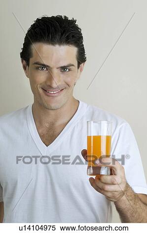 Stock Photography - Young man holding a glass of juice. Fotosearch