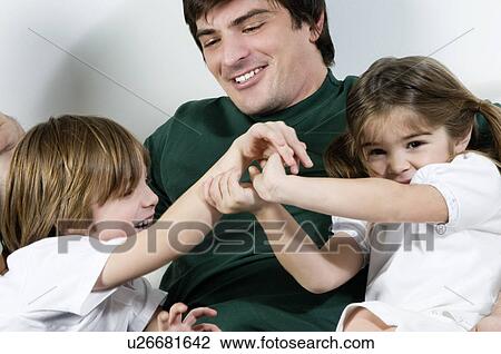 Young man on couch with children playing View Large Photo Image Stock Image - Young man on couch with children playing. Fotosearch