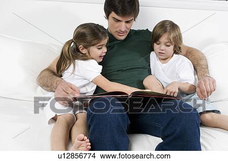 Young man on couch with children reading View Large Photo Image Picture - Young man on couch with children reading. Fotosearch