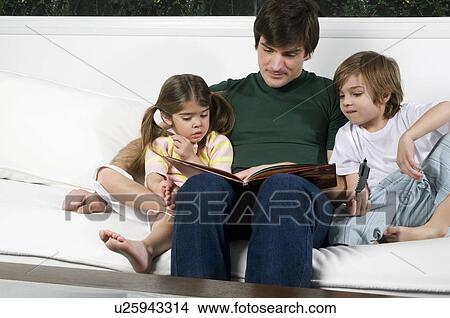 Young man on couch with children reading View Large Photo Image Picture - Young man on couch with children reading. Fotosearch
