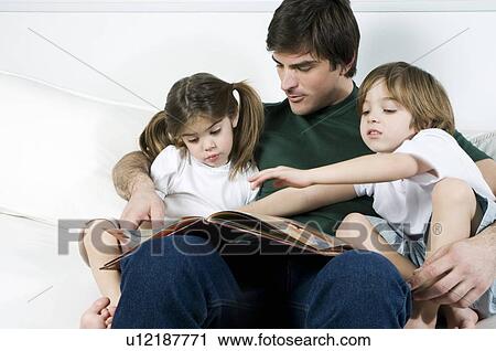 Young man on couch with children reading View Large Photo Image Stock Image - Young man on couch with children reading. Fotosearch