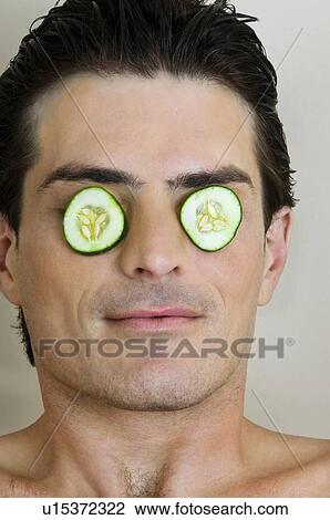 Young man with cucumber slices on his eyes View Large Photo Image Stock Image - Young man with cucumber slices on his eyes. Fotosearch