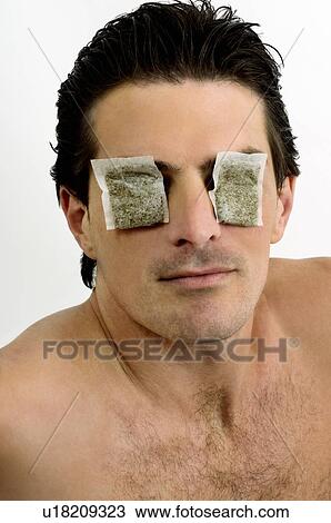 Young man with tea bags on his eyes View Large Photo Image Stock Image - Young man with tea bags on his eyes. Fotosearch