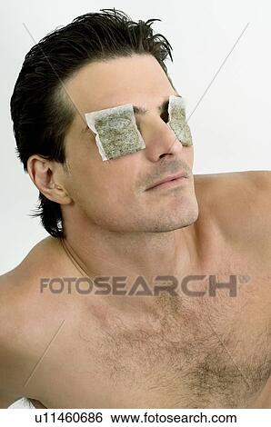 Young man with tea bags on his eyes View Large Photo Image Stock Photograph - Young man with tea bags on his eyes. Fotosearch