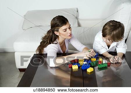 Young woman and boy playing with building blocks View Large Photo Image Stock Image - Young woman and boy playing with building blocks. Fotosearch
