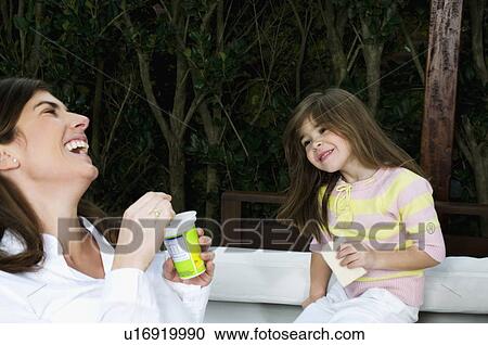 Young woman and girl having breakfast outdoors View Large Photo Image Stock Image - Young woman and girl having breakfast outdoors. Fotosearch