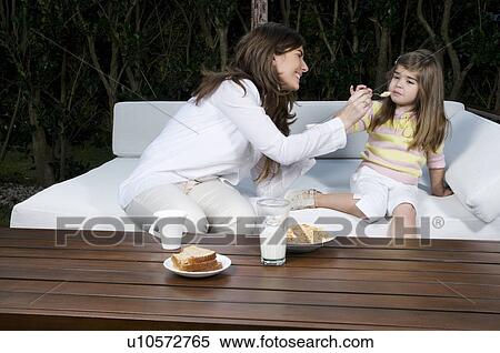 Young woman and girl having breakfast outdoors View Large Photo Image Stock Photography - Young woman and girl having breakfast outdoors. Fotosearch