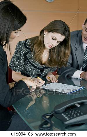 "Young woman signing document, professional woman pointing" View Large Photo Image Stock Photography - "Young woman signing document, professional woman pointing". Fotosearch