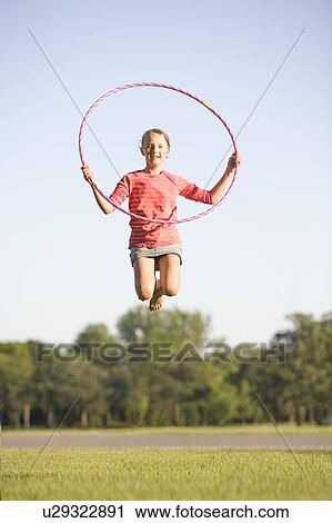 Stock Image - 11 year old girl jumps high with hoop, Winnipeg, Canada. Fotosearch