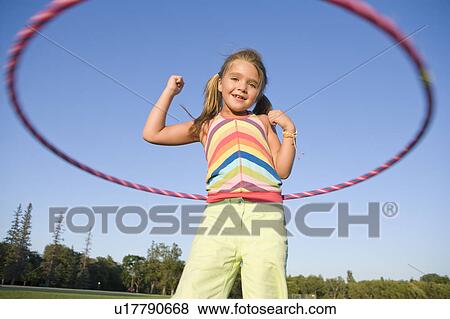 Stock Photo - 6 year old girl playing with hula hoop, Winnipeg, Canada. Fotosearch