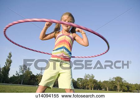 Stock Photography - 6 year old girl playing with hula hoop, Winnipeg, Canada. Fotosearch