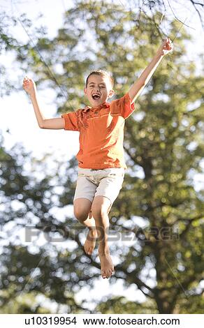 Picture - 8 year old boy jumping, Winnipeg, Canada. Fotosearch