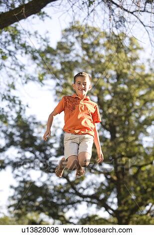 Stock Photograph - 8 year old boy jumping, Winnipeg, Canada. Fotosearch
