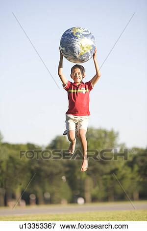 8 year old boy jumping with earth-patterned ball, Winnipeg, Canada View Large Photo Image Stock Photo - 8 year old boy jumping with earth-patterned ball, Winnipeg, Canada. Fotosearch