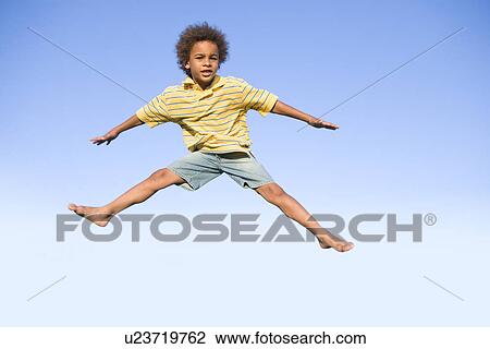 Stock Image - 8 year old boy jumps very high, Winnipeg, Canada. Fotosearch