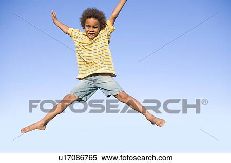 Stock Photography - 8 year old boy jumps very high, Winnipeg, Canada. Fotosearch
